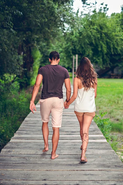 Couple tenant la main et marchant sur la jetée — Photo