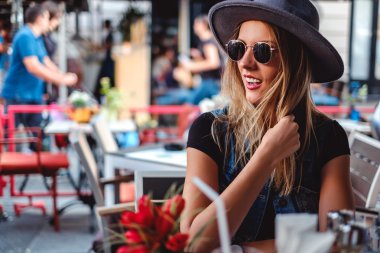 Bir kafede otururken gülümseyen kız