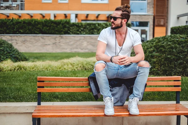 Hipster con uomo panino seduto sulla panchina del parco — Foto Stock