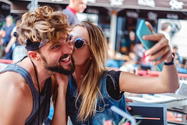 Ragazza baciare fidanzato mentre prende selfie — Foto Stock