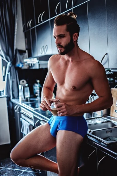 Чоловік в нижній білизні п'є каву на кухні — стокове фото