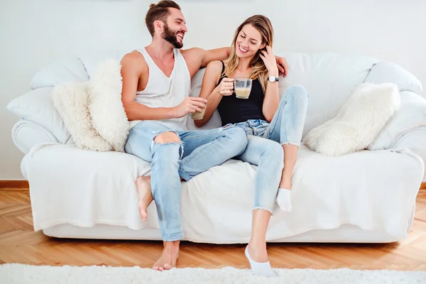 Couple talking and laughing on the couch — Stock Photo, Image