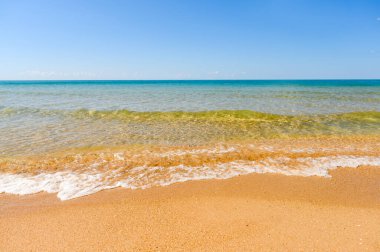 Güneşli bir günde deniz kıyısında. Deniz teması ve rahatlama üzerine bir arka plan. Suyun kenarına odaklan..