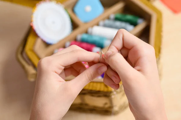 針の手には 縫製用品の背景に針と糸を縫います 糸をミシン針に差し込む — ストック写真