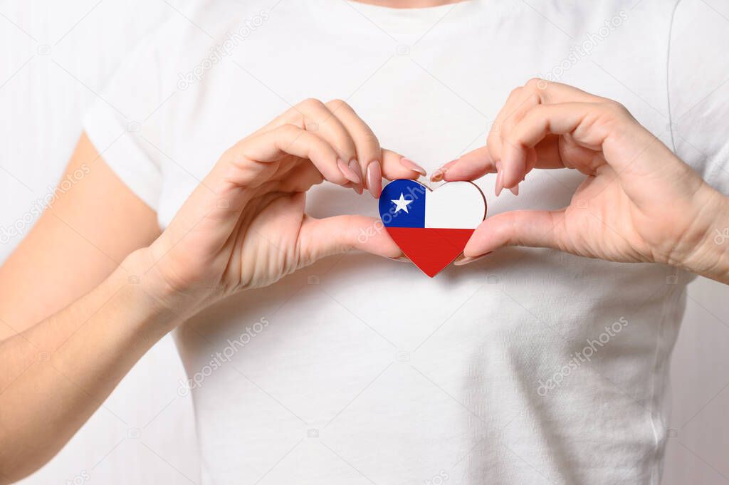 Love Chile. On her chest, the girl holds a heart in the form of the flag of Chile. Chilean Concept of Patriotism
