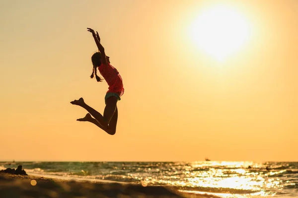 Menina Está Pulando Alegria Praia Ponto Fundo Belo Pôr Sol — Fotografia de Stock