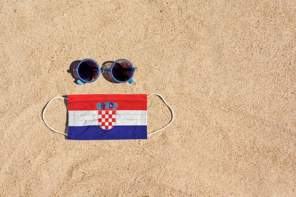 Una Máscara Médica Color Bandera Croacia Encuentra Playa Arena Junto — Foto de Stock