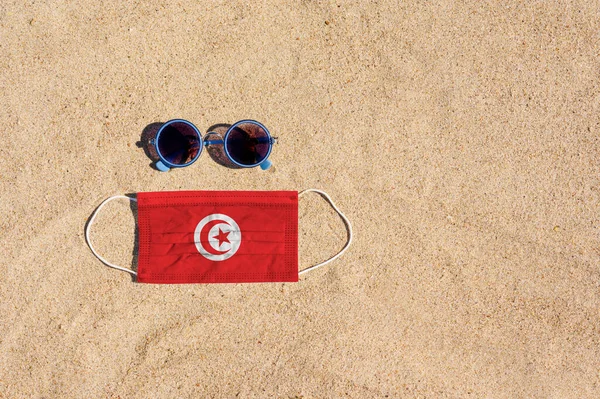 Lékařská Maska Barvě Tuniské Vlajky Leží Písečné Pláži Vedle Sklenic — Stock fotografie
