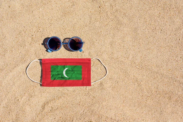 Uma Máscara Médica Cor Bandeira Das Maldivas Fica Praia Areia — Fotografia de Stock