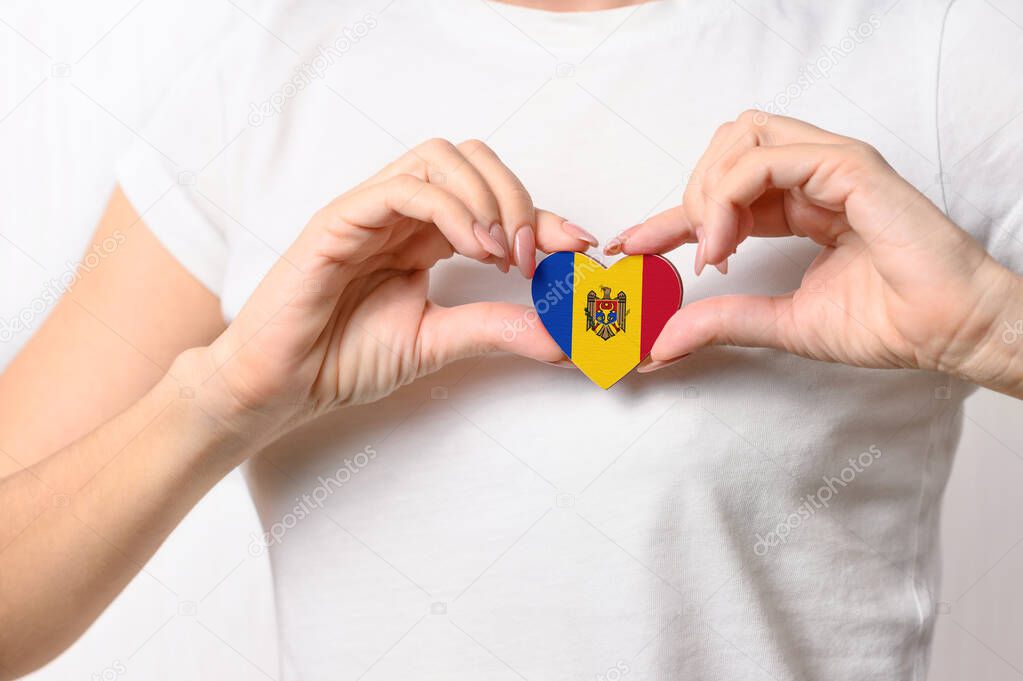 Love Moldova. The girl holds a heart in the form of the flag of Moldova on her chest. Moldovan patriotism concept