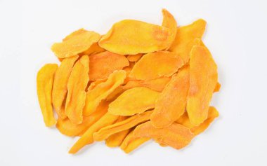 Beyaz bir tabakta kurumuş mango dilimleri. Yukarıdan görüntüle.