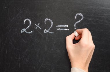 Okul yönetim kurulundaki erkek bir örnek yazıyor. Soru işareti olan basit bir matematik sorusu.