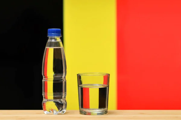 Butelka Czystej Wody Pitnej Szklany Stojak Stole Tle Flagi Belgii — Zdjęcie stockowe