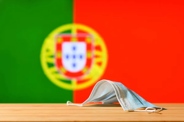 Медицинская Маска Лежит Столе Фоне Флага Португалии Концепция Обязательного Режима — стоковое фото