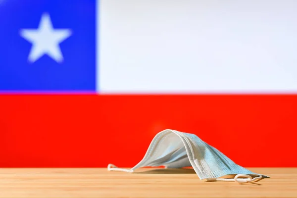 Медицинская Маска Лежит Столе Фоне Чилийского Флага Концепция Обязательного Режима — стоковое фото