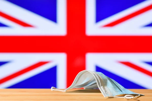 Vor Dem Hintergrund Der Flagge Großbritanniens Liegt Eine Medizinische Maske — Stockfoto