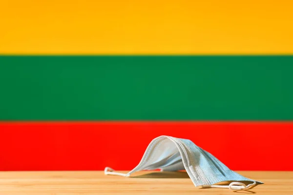 Uma Máscara Médica Está Sobre Mesa Contra Fundo Bandeira Lituânia — Fotografia de Stock