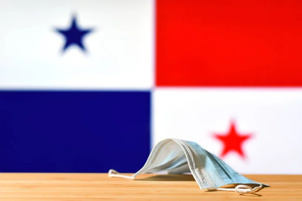 パナマの国旗を背景に医療用マスクがテーブルの上に置かれている パンデミックの間のパナマの国内および観光客のための強制マスク制度の概念 — ストック写真
