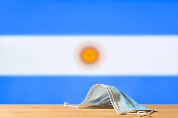 Una Máscara Médica Yace Sobre Mesa Fondo Bandera Argentina Concepto —  Fotos de Stock