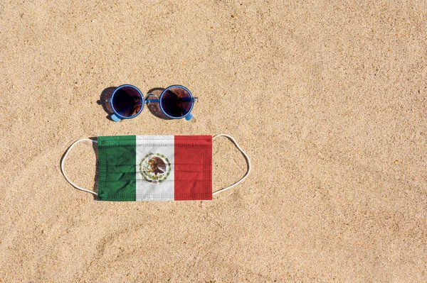 Maska Medyczna Kolorze Flagi Meksyku Leży Piaszczystej Plaży Obok Okularów — Zdjęcie stockowe