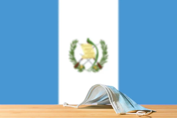 Una Máscara Médica Yace Sobre Mesa Trasfondo Bandera Guatemala Concepto —  Fotos de Stock