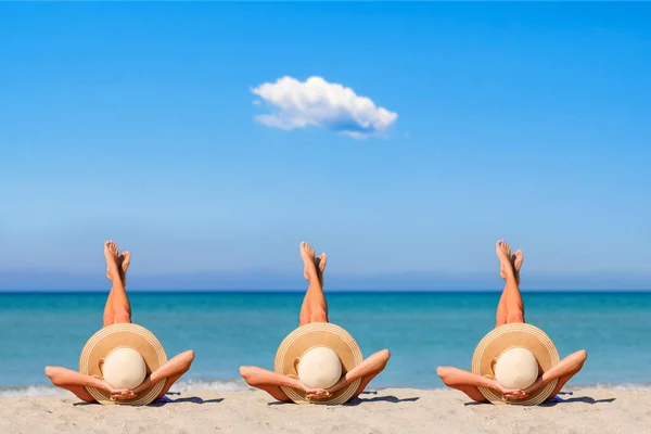 足を逆さまにして藁帽子をかぶった女の子がビーチで日光浴をしています 海による休暇の概念 — ストック写真