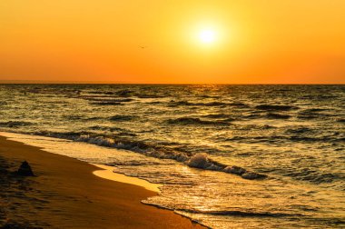 Romantik akşam deniz manzarası. Harika gün batımı. Seçici bir şekilde ön plana ve suyun kenarına odaklan..
