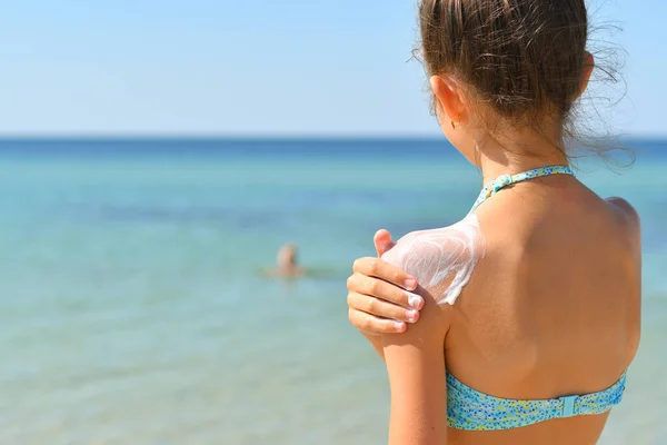 Menina Praia Esfrega Protetor Solar Seu Ombro Olha Para Mar — Fotografia de Stock