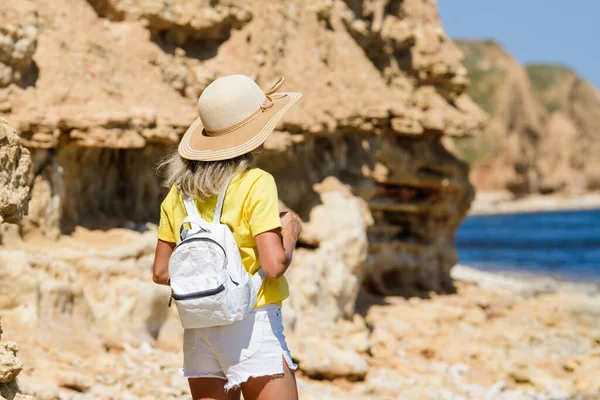 Ένα Κορίτσι Τουρίστρια Ψάθινο Καπέλο Μια Όμορφη Βραχώδη Ακτή Στέκεται — Φωτογραφία Αρχείου