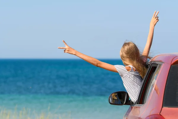 Ein Fröhliches Mädchen Mit Erhobenen Händen Blickt Aus Dem Autofenster — Stockfoto