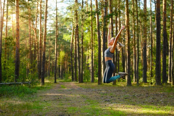 Ein Sportliches Mädchen Springt Mit Erhobenen Händen Einen Kiefernwald Selektive — Stockfoto