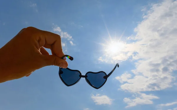 Gafas Sol Forma Corazones Una Mano Sobre Fondo Cielo Rayos — Foto de Stock