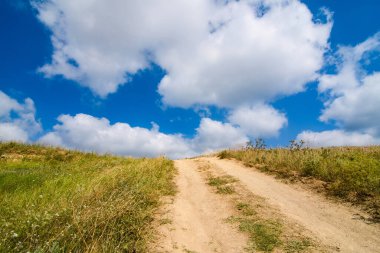 Tepedeki toprak yol gökyüzüne yükseliyor..