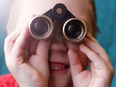 Bir çocuk tiyatro dürbününden çok yakından bakar.