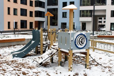 Evin karlı avlusunda çocuk parkı, kış mevsimi.