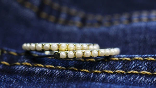 Diamond Earrings on a blue jeans, macro