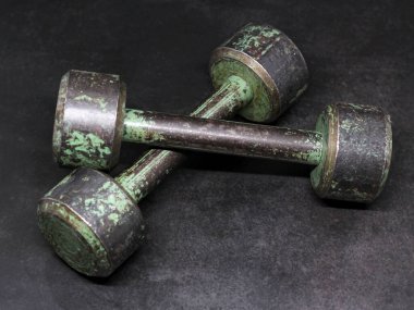 Siyah arka planda paslı bir dambıl, çok yakın.