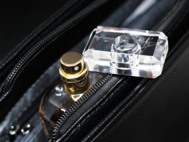 Kahverengi parfüm bardağı kadın deri çantasına çok yakın