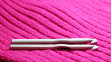 Pembe bir atkıya iki örgü kancası çok yakın.