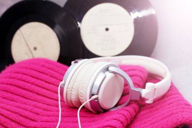 Pembe bir eşarpta beyaz, zarif kulaklıklar. Pembe bir arkaplan.