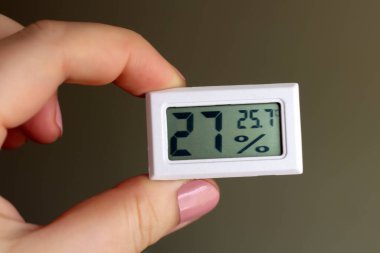 Bir kadının elindeki nem ve sıcaklığı ölçen bir cihaz.