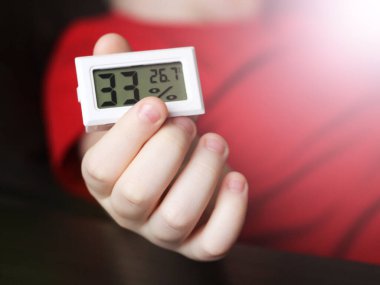 Bir çocuğun el iklimi kontrolündeki nemi ve sıcaklığı ölçmek için bir aygıt