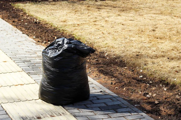 Sokakta çöp dolu siyah bir çanta.