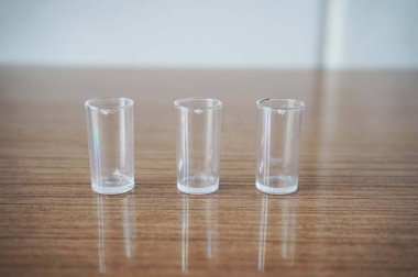 Tahta bir yüzeyde 3 Minyatür Temiz Kadeh. Tahta Masada Üç Küçük, Temiz Şat Bardağı