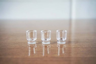 Tahta bir yüzeyde 3 Minyatür Temiz Kadeh. Tahta Masada Üç Küçük, Temiz Şat Bardağı