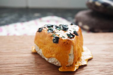 Japon Onigiri 'nin bire bir kopyası, üstüne mentai sosu ve ahşap arka planda deniz yosunu. Lezzetli Asya yemeklerinin yakın görüntüsü