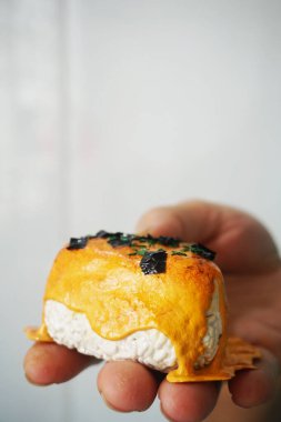 Elinizde erimiş peynir ve yosunla onigiri taklidi var. Seçici odaklanma. Çamur sanatı Gıda taklit.
