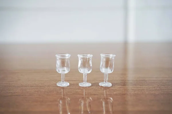 Tahta bir yüzeyde 3 Minyatür Temiz Kadeh. Tahta Masada Üç Küçük, Temiz Şat Bardağı