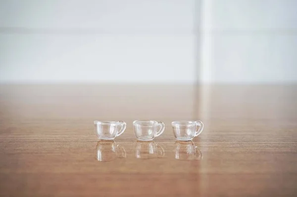 Tahta bir yüzeyde 3 Minyatür Temiz Kadeh. Tahta Masada Üç Küçük, Temiz Şat Bardağı