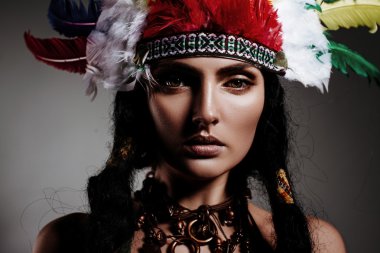 Hint tarzı gri arka plan üzerinde parlak tüylü şapkalı güzel kız modeli